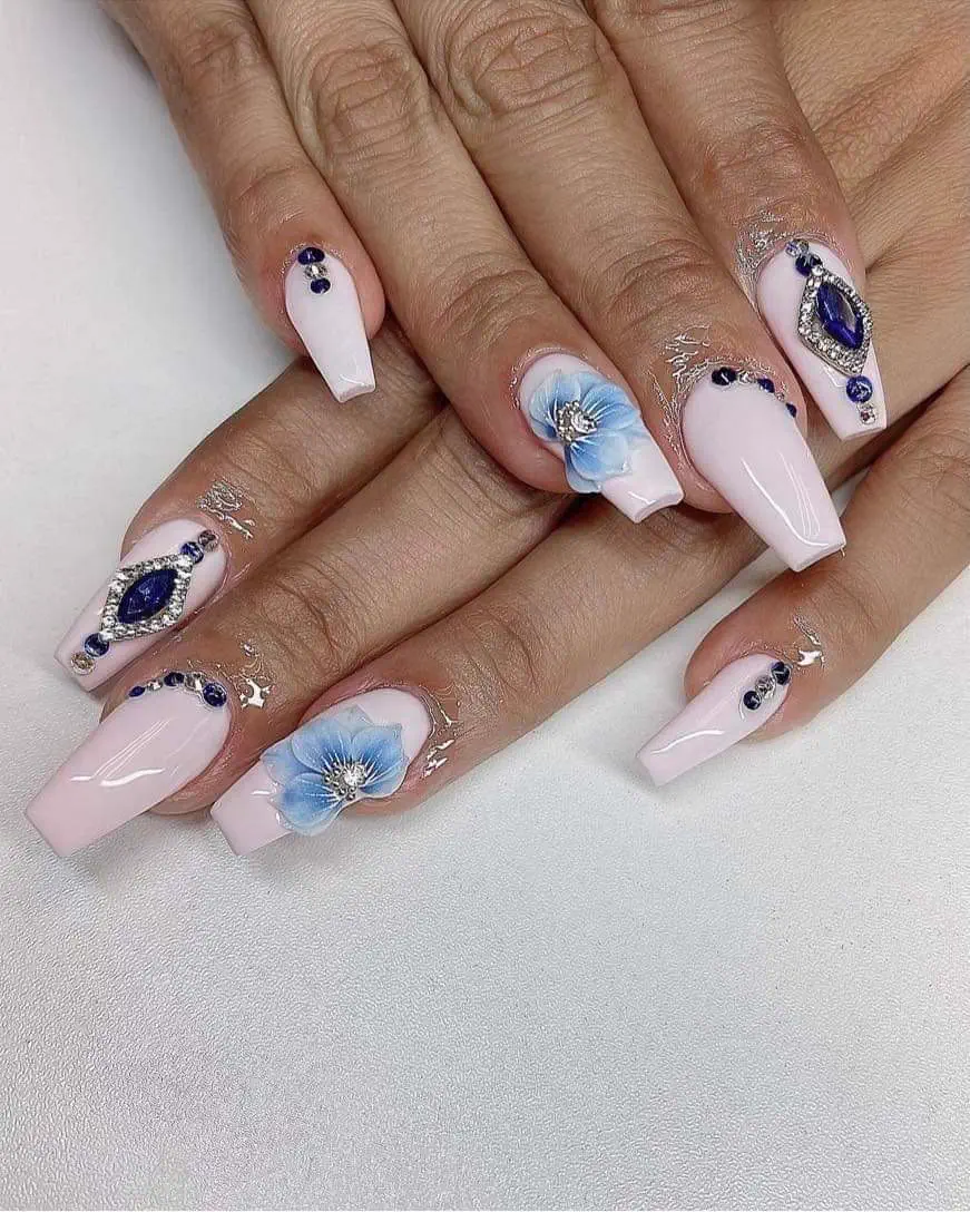 Long pale pink coffin nails with hand-painted blue 3D flowers and navy gems