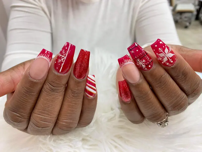 Two hands with a red glitter and candy-stripe holiday set